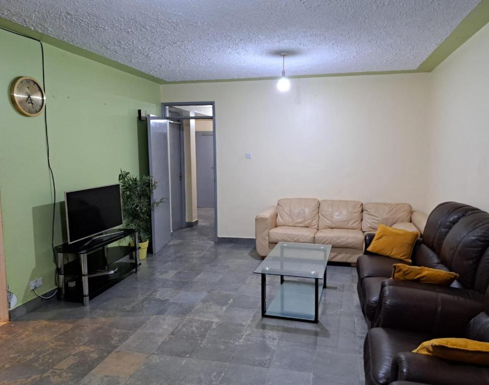 a living room with a couch and a tv at Mfalme House, Ngoingwa Estate, 100 Metres from Thika-Mangu Rd, Close to Thika City Centre - Free Parking, Fast Wi-Fi, Smart TV, 2 Bedrooms Perfect for a Family of 2-4 Members in Thika