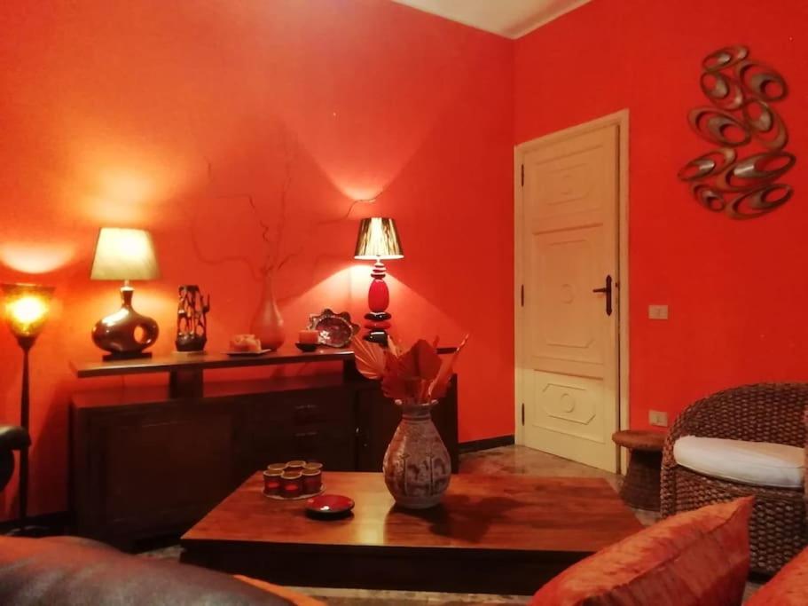 ein rotes Wohnzimmer mit einer Blumenvase auf dem Tisch in der Unterkunft Il Rifugio delle Rondini in Muravera