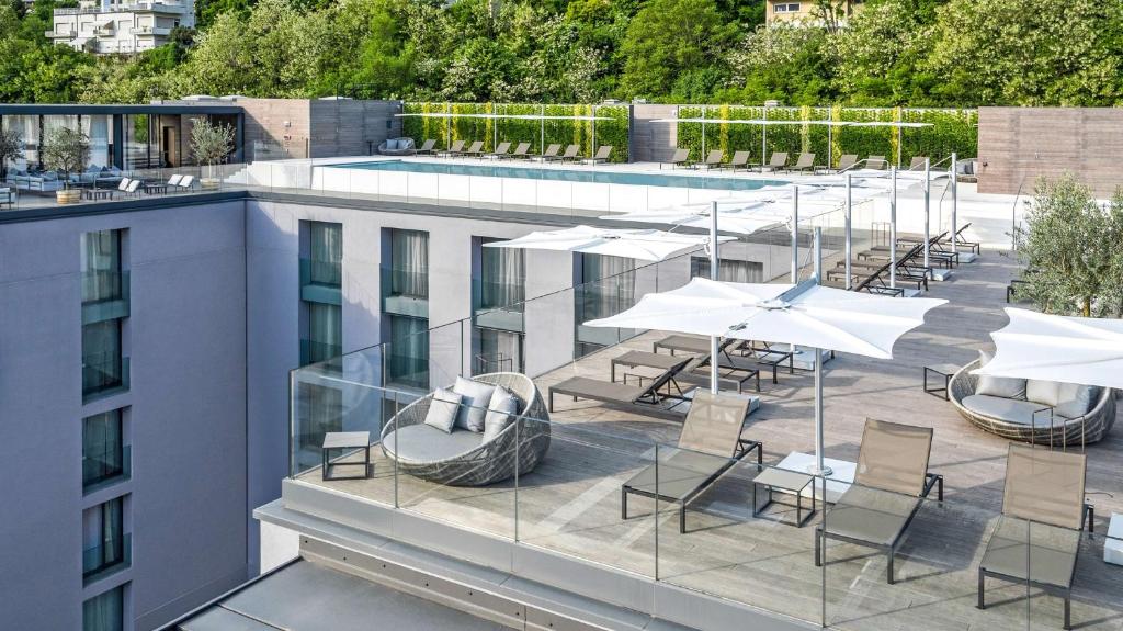 a balcony with tables and umbrellas on a building at Hilton Lake Como in Como