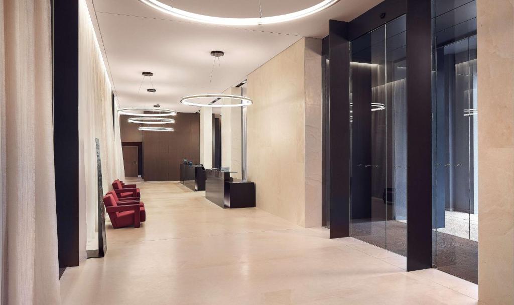 a hallway with red chairs in a office building at Hilton Lake Como in Como