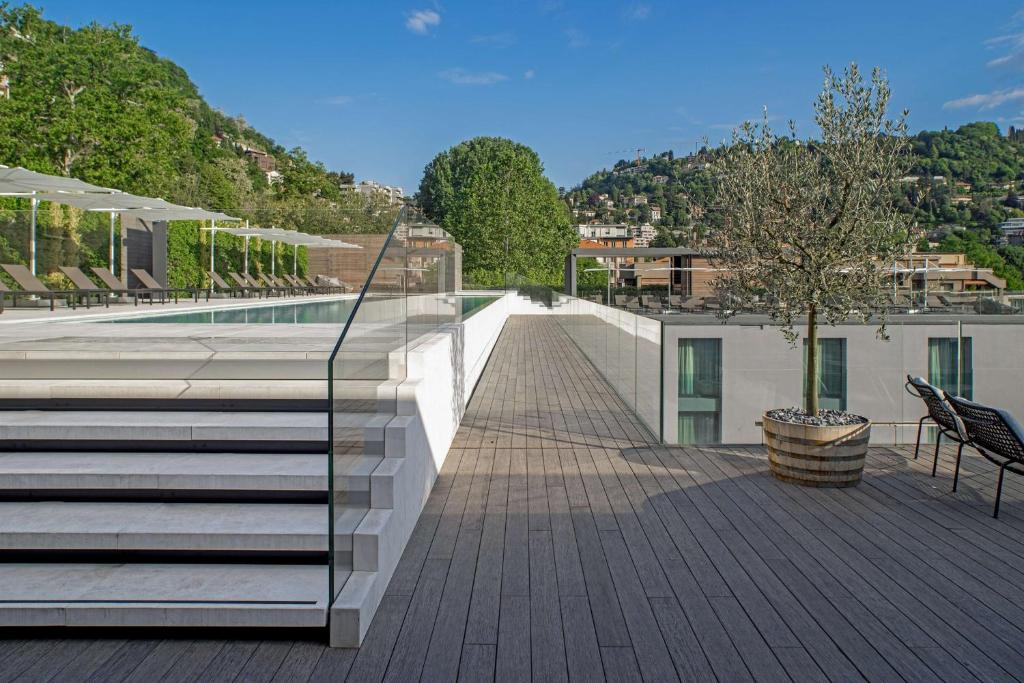 a deck with stairs and a swimming pool on a house at Hilton Lake Como in Como