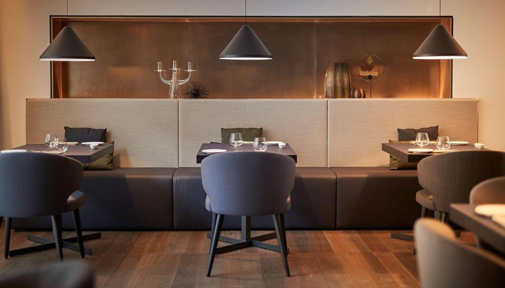 a dining room with tables and chairs in a restaurant at Hilton Lake Como in Como