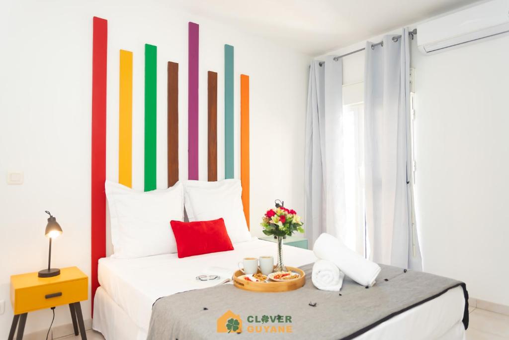 1 dormitorio con 1 cama con cabecero colorido en Le nuancier au centre-ville près du Mcdonald&#39;s, en Cayenne