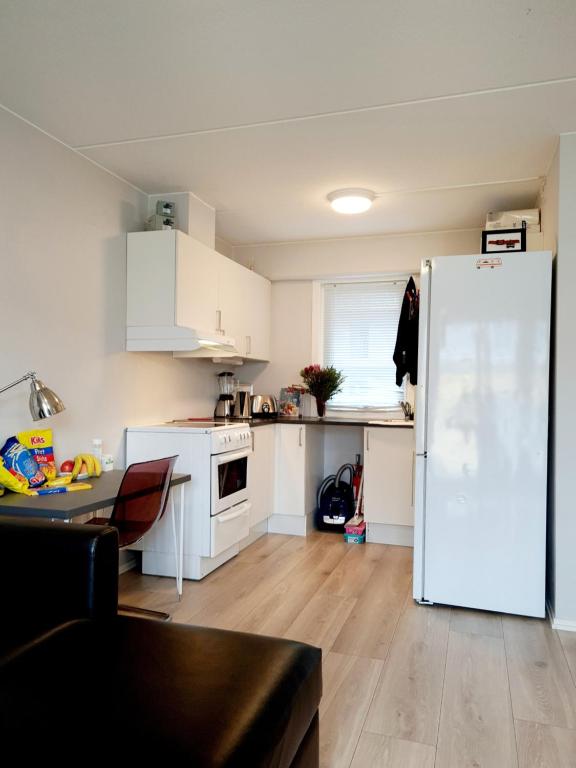a kitchen with white cabinets and a white refrigerator at Modern central apartment next to beautiful nature2424 in Oslo