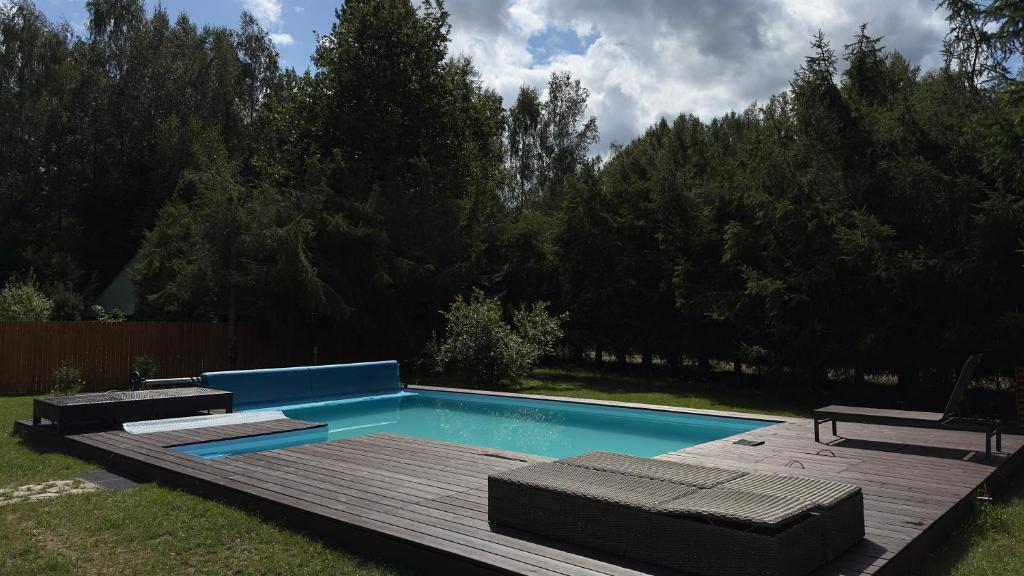 a swimming pool in a yard with a wooden deck at Leśny Raj in Świętajno