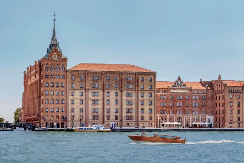 a boat in the water in front of a large building at Hilton Molino Stucky Venice in Venice