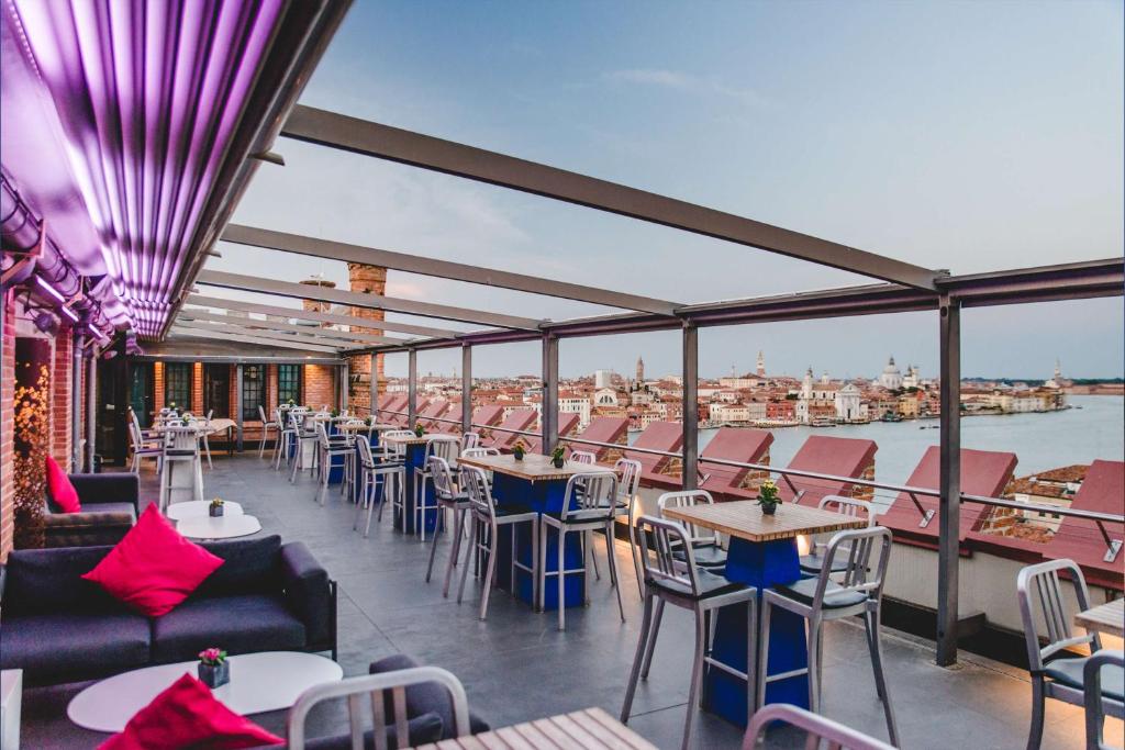 a balcony of a restaurant with tables and chairs at Hilton Molino Stucky Venice in Venice