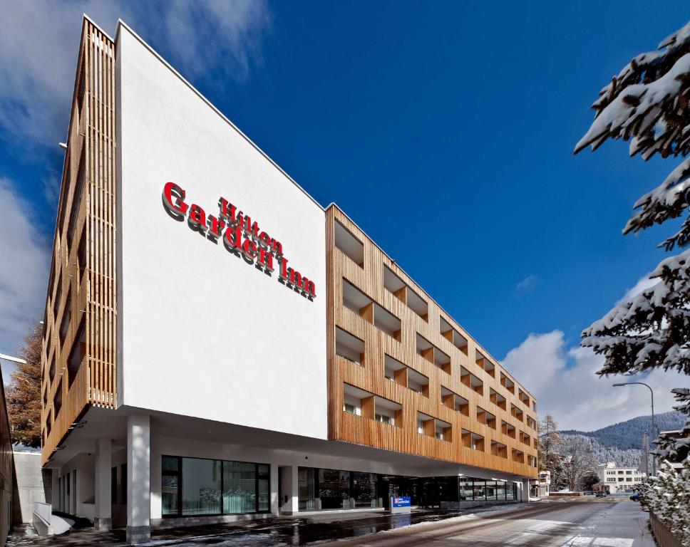 a building with a sign on the side of it at Hilton Garden Inn Davos in Davos