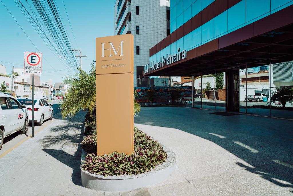 un cartel en una acera frente a un edificio en Hotel Manaíra, en João Pessoa