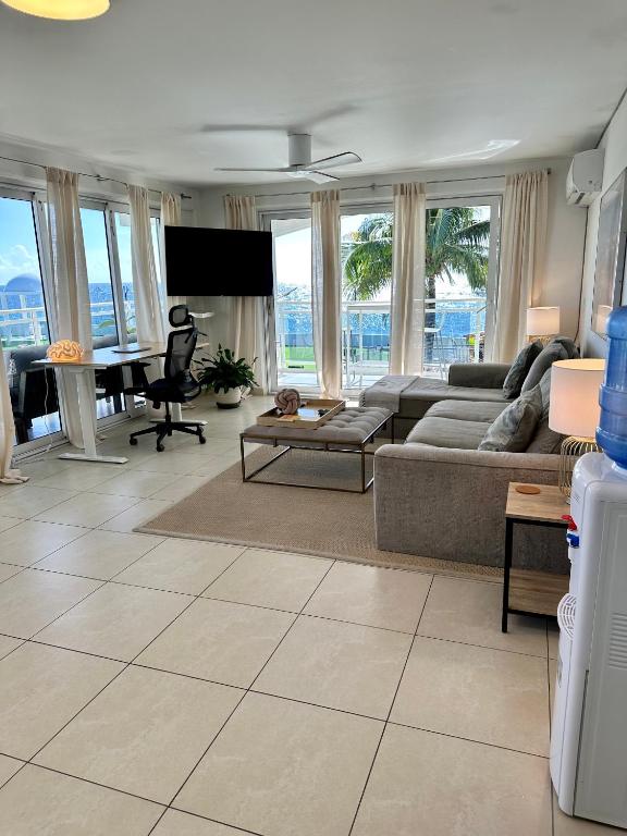 un soggiorno con un divano e un tavolo di Maho Beach House - Luxe 1 Bedroom - Ocean Hideaway a Maho Reef