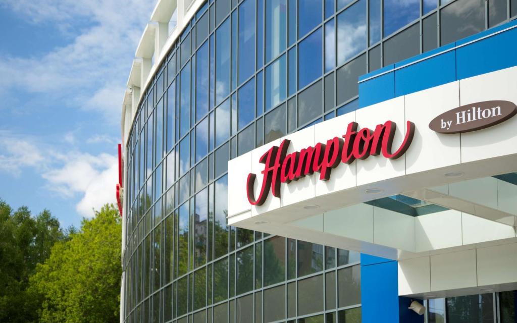 um sinal de empresa na lateral de um edifício em Hampton by Hilton Nizhny Novgorod em Níjni Novgorod