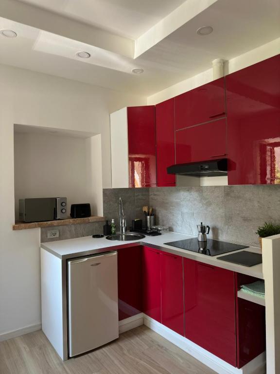 una cocina con armarios rojos y fregadero en Apartment Lake Varese - Lago di Varese -, en Lomnago