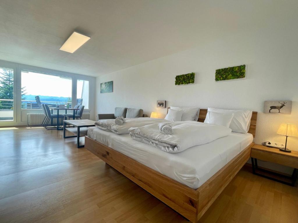 a bedroom with a large bed with white sheets at FeWo Längl -Waldluft- mit Pool und Sauna im Allgäu in Scheidegg