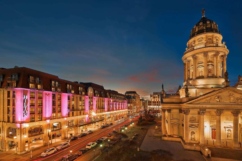 柏林的住宿－希爾頓柏林酒店，一座在晚上在城市里建有钟楼