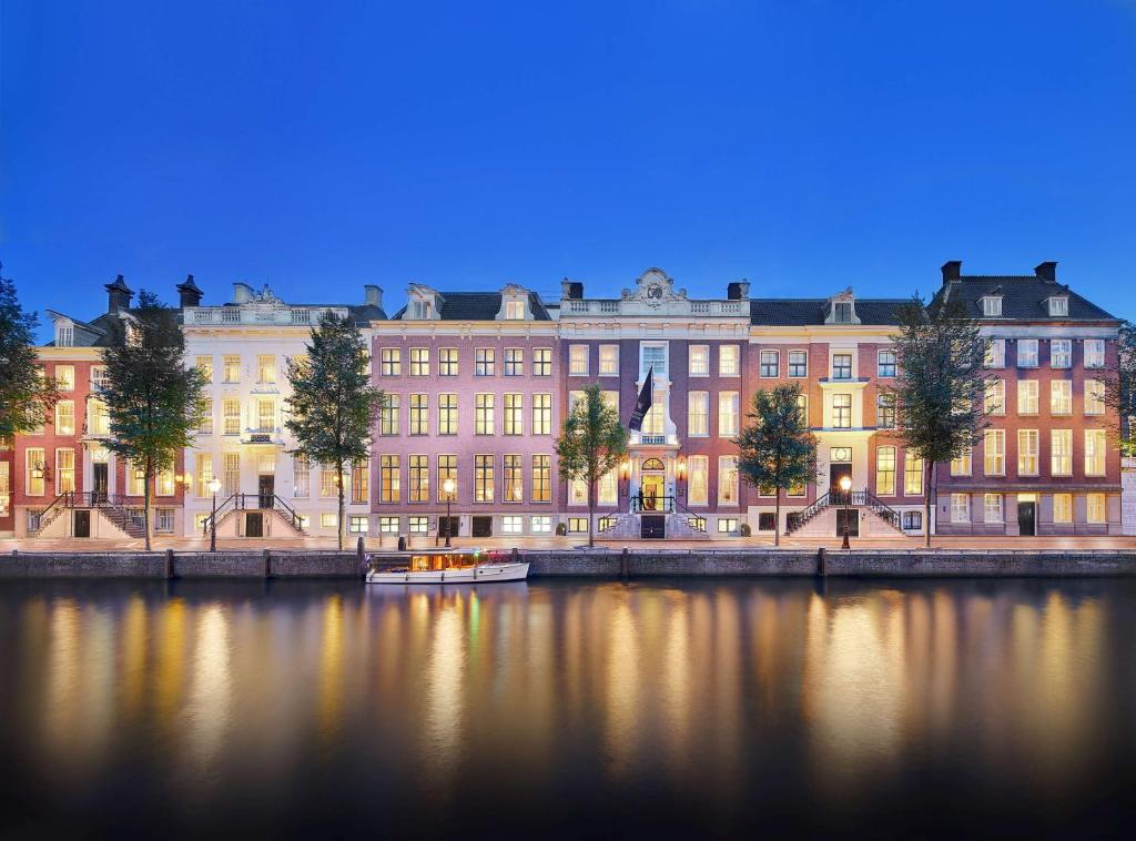 a large building next to a body of water at Waldorf Astoria Amsterdam in Amsterdam