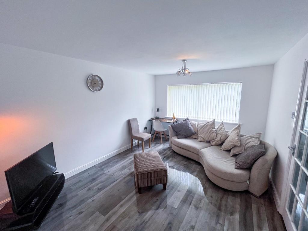 a living room with a couch and a table at The Quiet Sanctuary - 4 Bedroom in Swindon