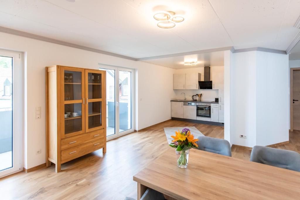 a living room with a table and chairs and a kitchen at Moderne Ferienwohnung direkt am Wasser in Heiligenstadt