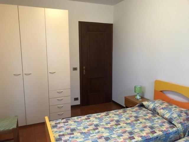 a bedroom with a bed and a dresser and a closet at Villetta Indipendente in San Zeno di Montagna