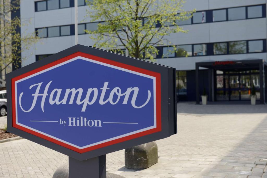 una señal frente a un edificio en Hampton by Hilton Amsterdam Airport Schiphol en Hoofddorp