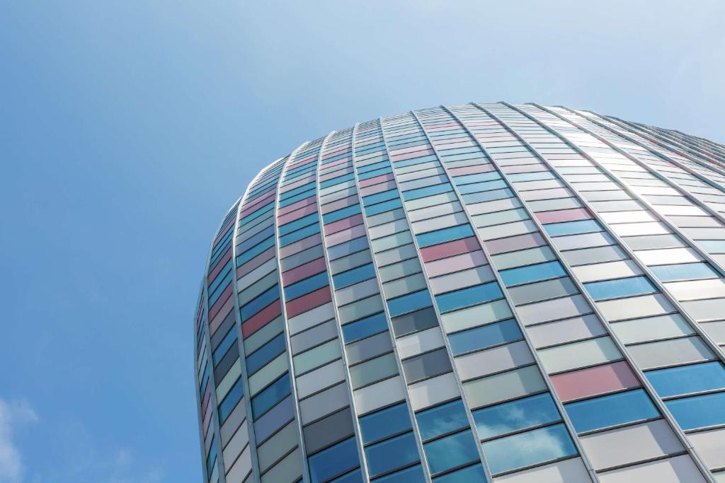 een hoog kantoorgebouw met kleurrijke ramen bij Hampton By Hilton Utrecht Centraal Station in Utrecht