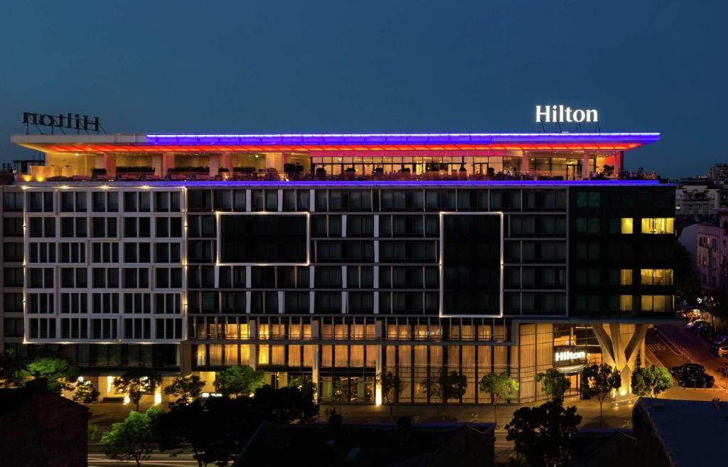 a hotel building with a hilton at night at Hilton Belgrade in Belgrade