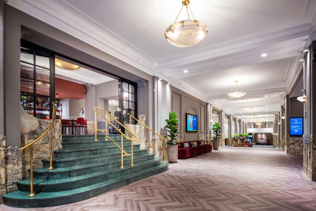 a lobby of a hotel with a green staircase at DoubleTree By Hilton Brussels City in Brussels