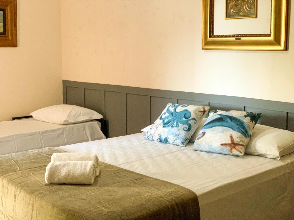 a bedroom with two beds with pillows on them at Pousada Praeros in Rifaina
