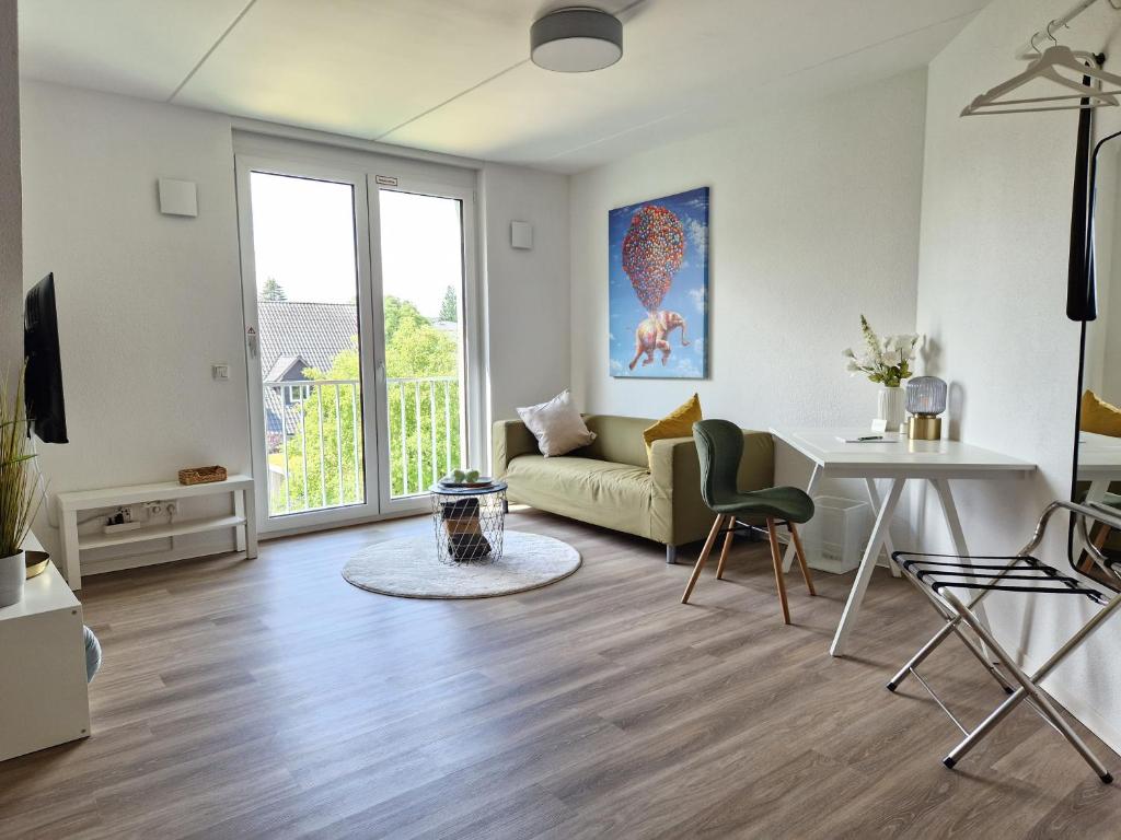 ein Wohnzimmer mit einem Sofa und einem Tisch in der Unterkunft Modern-Living Stadt-Appartement Mitte in Bielefeld
