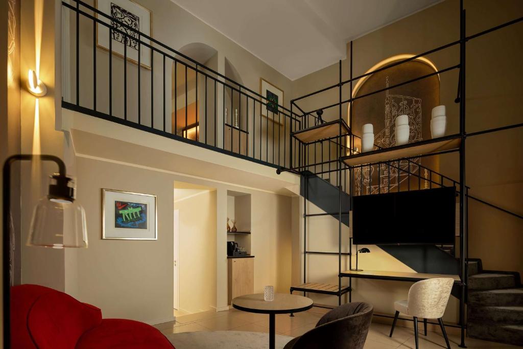 a living room with a spiral staircase and a table at Wasserturm Hotel Cologne, Curio Collection by Hilton in Cologne