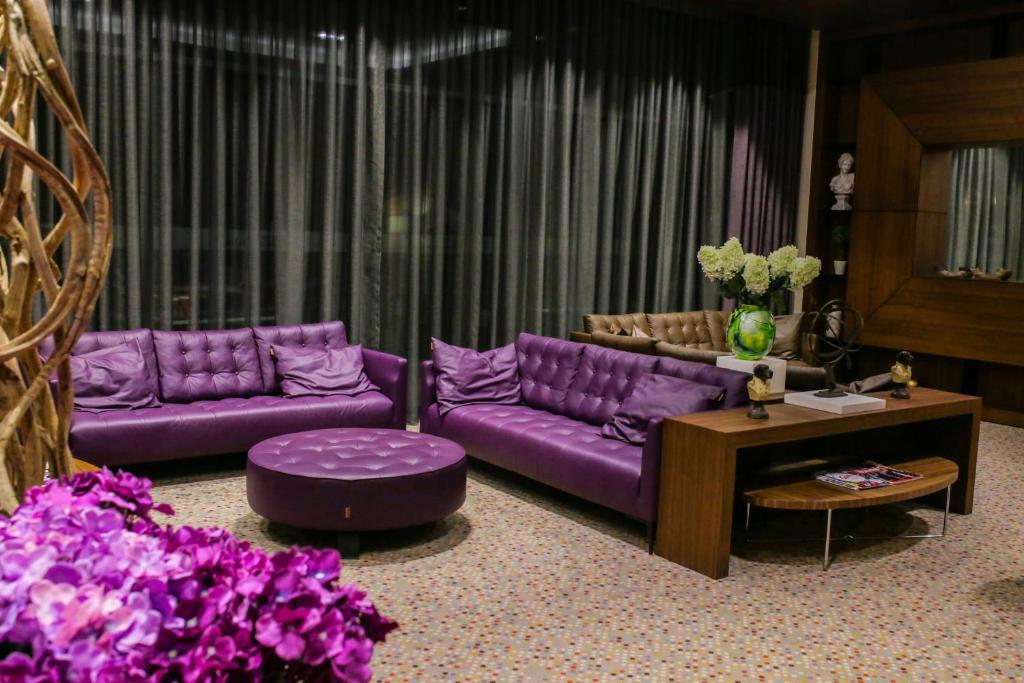 a living room with purple furniture and purple flowers at Hilton Garden Inn Eskisehir in Eskisehir