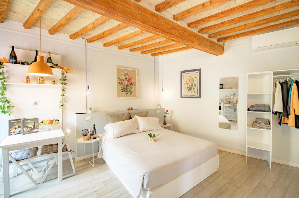 a bedroom with a white bed and a desk at La Casa del Vino in Parma