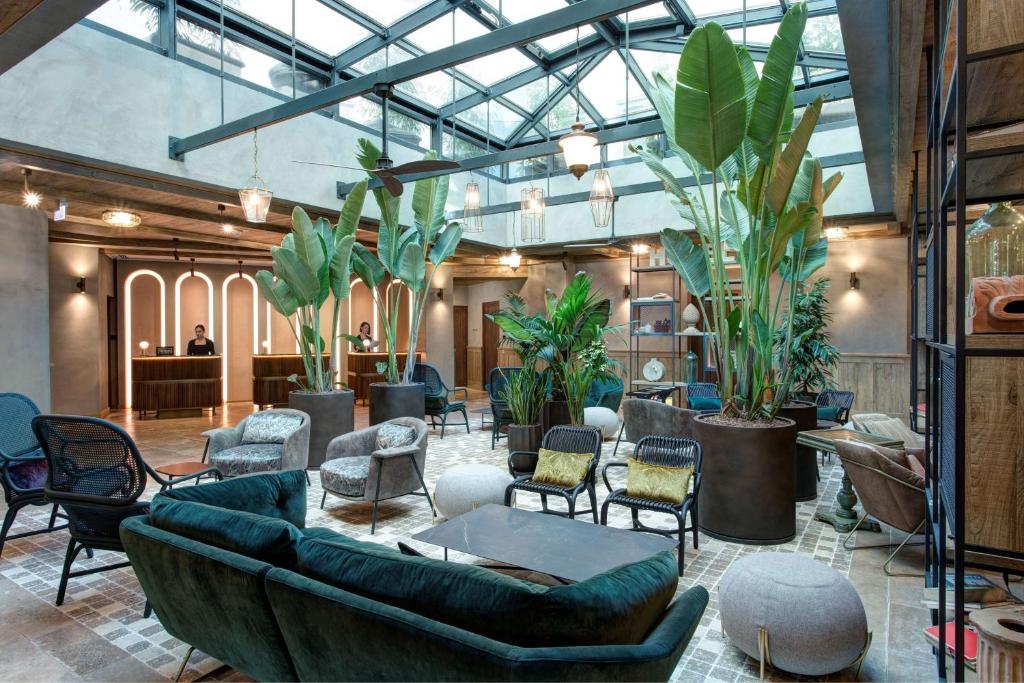 a lobby with couches and chairs and plants at DoubleTree By Hilton Rome Monti in Rome