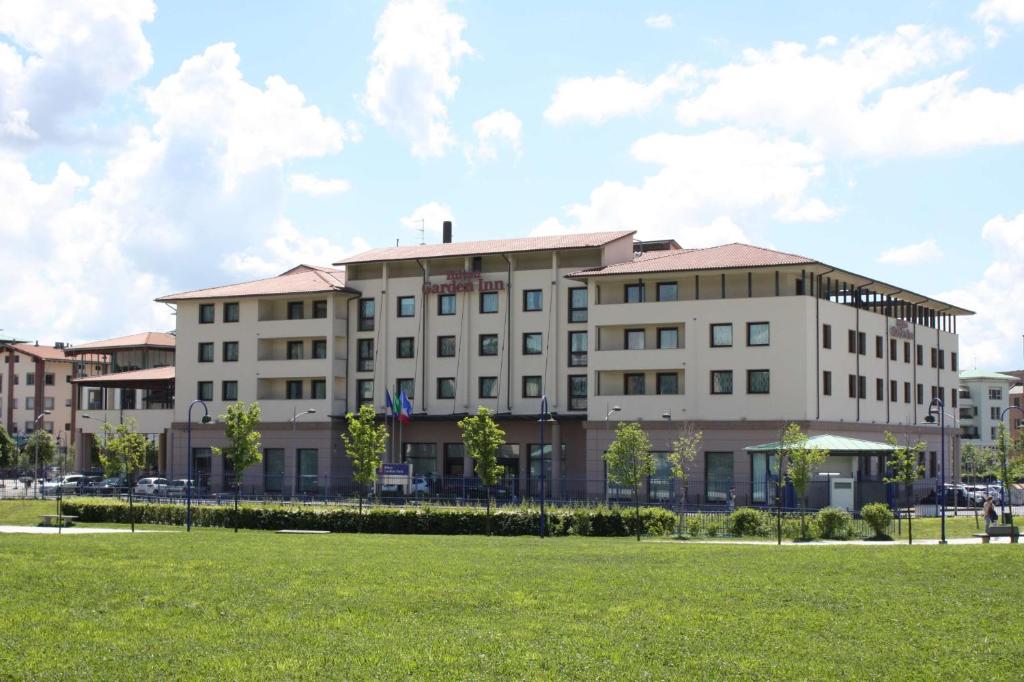 a large white building with a lawn in front of it at Hilton Garden Inn Florence Novoli in Florence