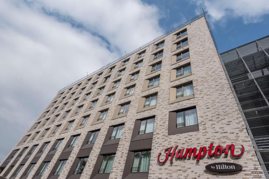 un edificio alto con un cartel en el costado en Hampton By Hilton Frankfurt City Centre East, en Frankfurt