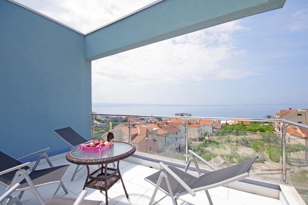 a balcony with a table and chairs and a view of the ocean at Tatiana Penthouse in Podstrana