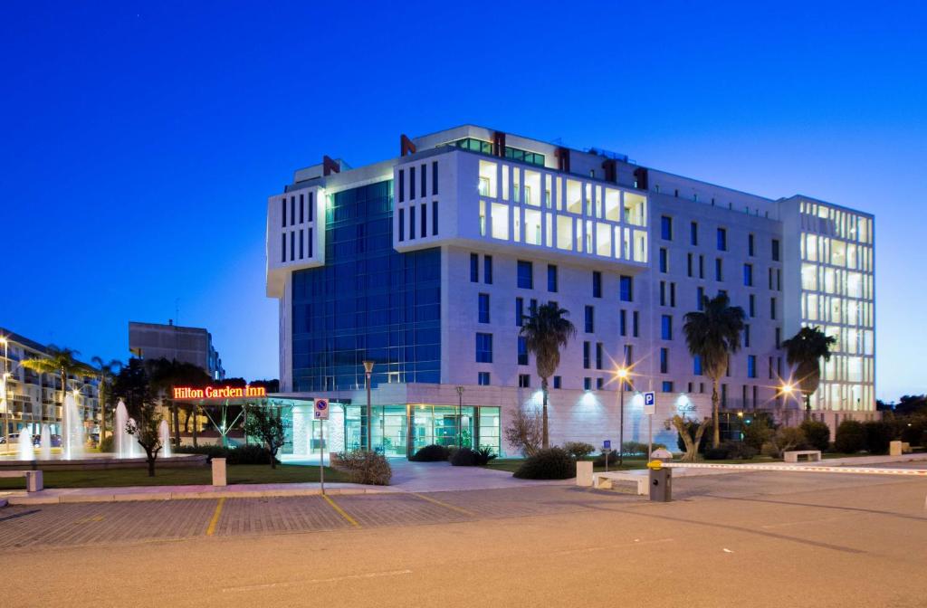 Un grand bâtiment blanc avec de nombreuses fenêtres dans l'établissement Hilton Garden Inn Lecce, à Lecce