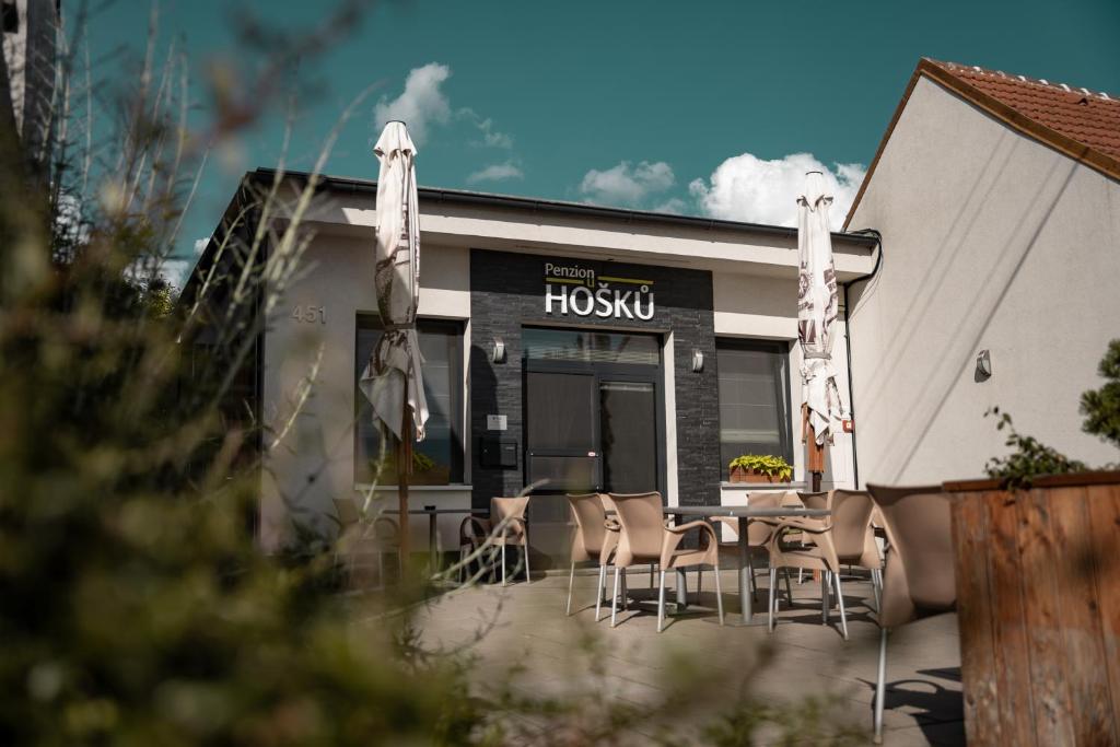 a restaurant with tables and chairs in front of a building at Penzion u Hošků in Vrbice