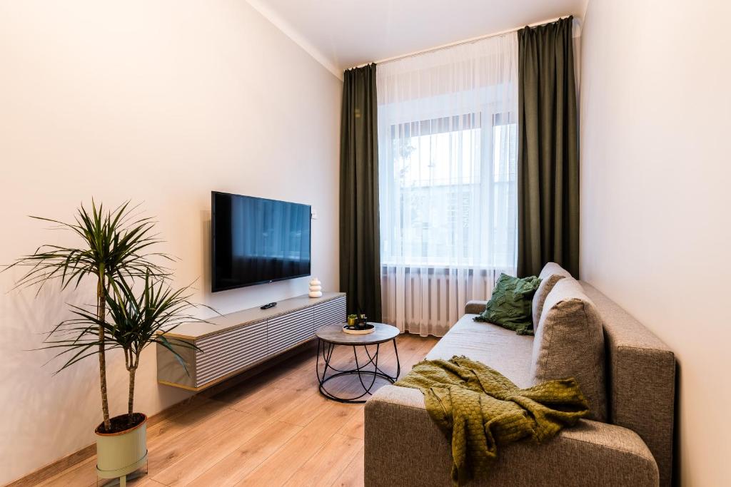 ein Wohnzimmer mit einem Sofa und einem Flachbild-TV in der Unterkunft Juozapaviciaus apartment in Kaunas