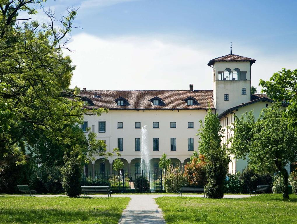 a large white building with a clock tower on top at Grand Hotel Villa Torretta, Curio Collection by Hilton in Sesto San Giovanni