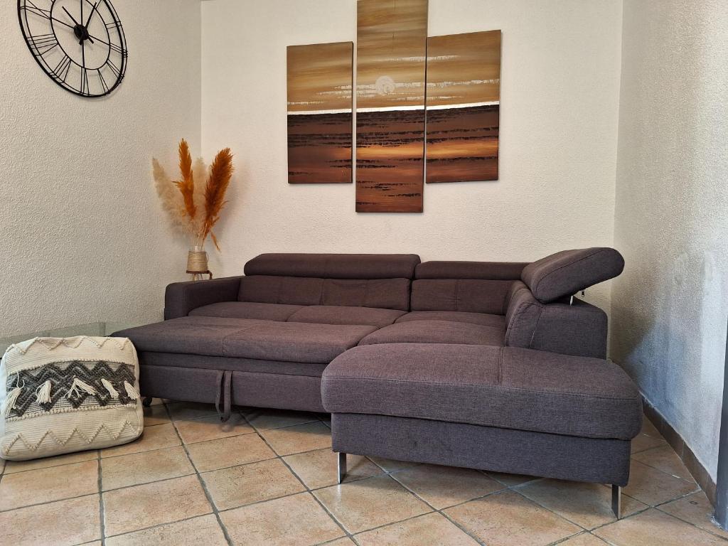 uma sala de estar com um sofá e um relógio em Appartement Stockholm em Gap