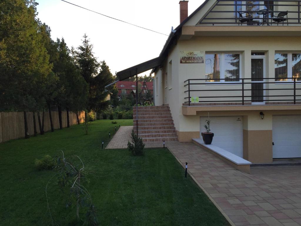 a house with a porch and a grass yard at Mimi Apartment in Nyíregyháza
