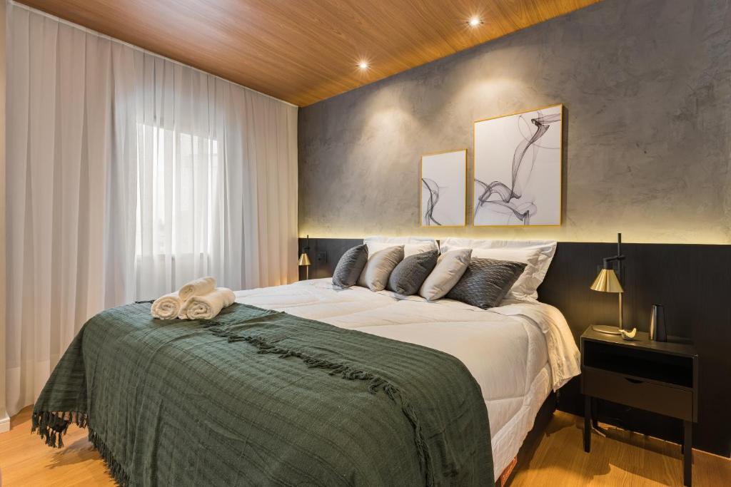 a bedroom with a large bed and a window at Cyclinn Jesuíno Arruda Itaim in São Paulo