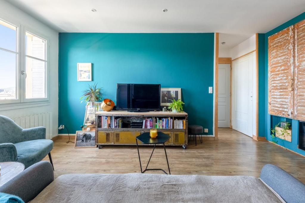sala de estar con TV y pared azul en Beautiful 2-room apartment with a view in Lyon - Welkeys, en Lyon