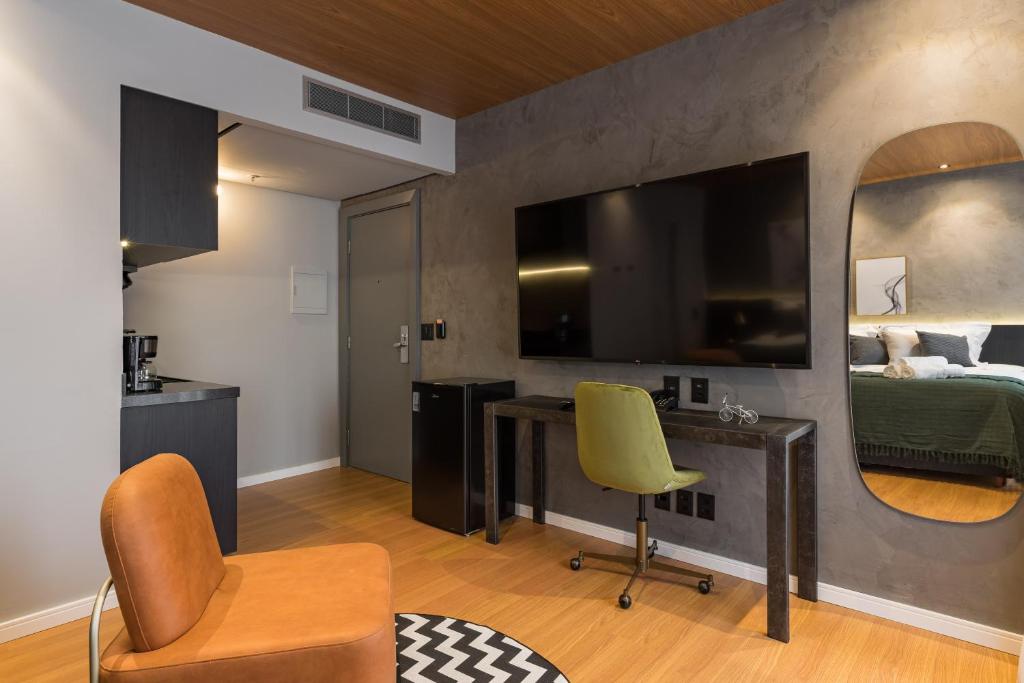 a room with a desk and a bed and a mirror at Cyclinn Jesuíno Arruda Itaim in São Paulo