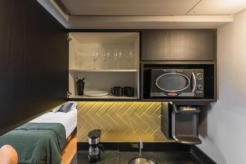 a small room with a bed and a tv at Cyclinn Jesuíno Arruda Itaim in São Paulo