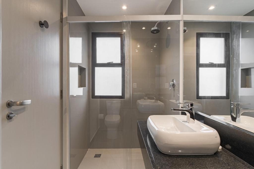 a bathroom with a white sink and a shower at Cyclinn Jesuíno Arruda Itaim in São Paulo