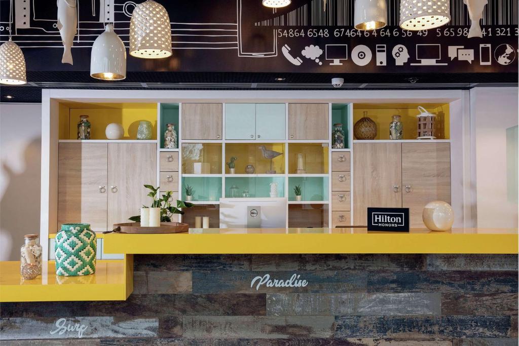a store display with a yellow counter in a room at Hampton By Hilton Paris Clichy in Clichy