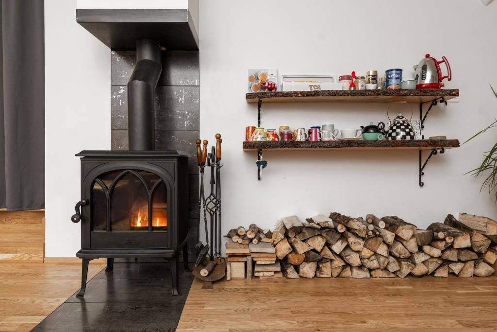 a fireplace in a living room with logs on the wall at Túnfífill Guesthouse - free hot tub and sauna, cozy and quiet in Hvammstangi