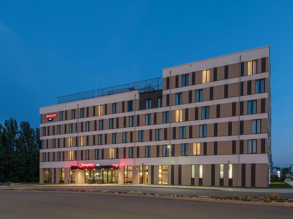 un grande edificio con luci alle finestre di Hampton By Hilton Freiburg a Friburgo in Brisgovia