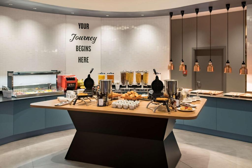 a restaurant with a counter with food on it at Hampton by Hilton Riga Airport in Riga